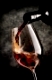 Wine pouring in wineglass on a black background